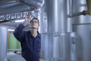 engineer-inspecting-pipes-in-power-station-2022-03-08-00-16-04-utc